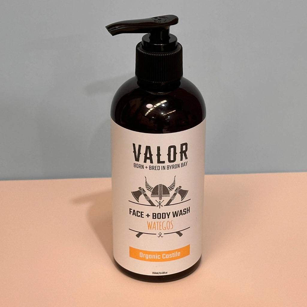 Bottle of Valor Castile face and body wash  Wategos on a beige surface with a gray background